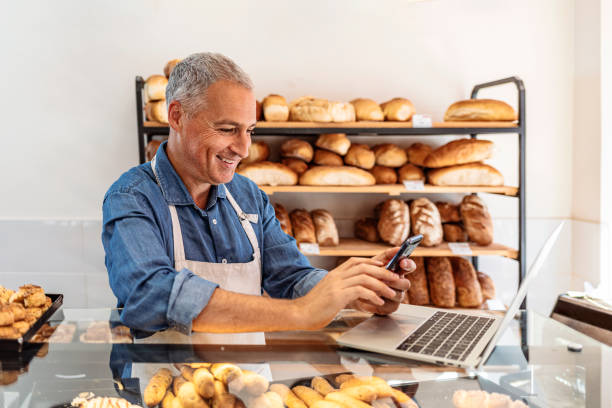 Cropped shot of a handsome mature businessman working in his local internet cafe or bakery shop.